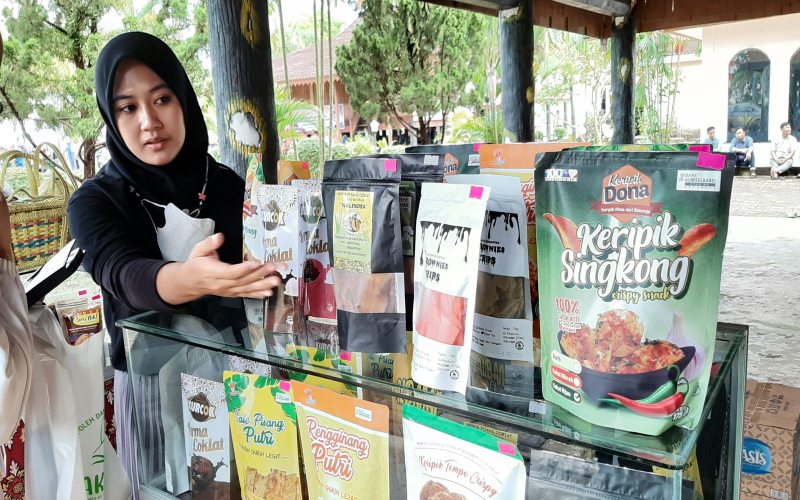 Petugas booth UMKM Sakinah, Regina Juliambarika, sedang menjelaskan produk-produk yang dijual di Festival Anjungan Sumatra Selatan 2022, Kamis (23/6/2022). -Bisnis - Aisya Fadilla Triana