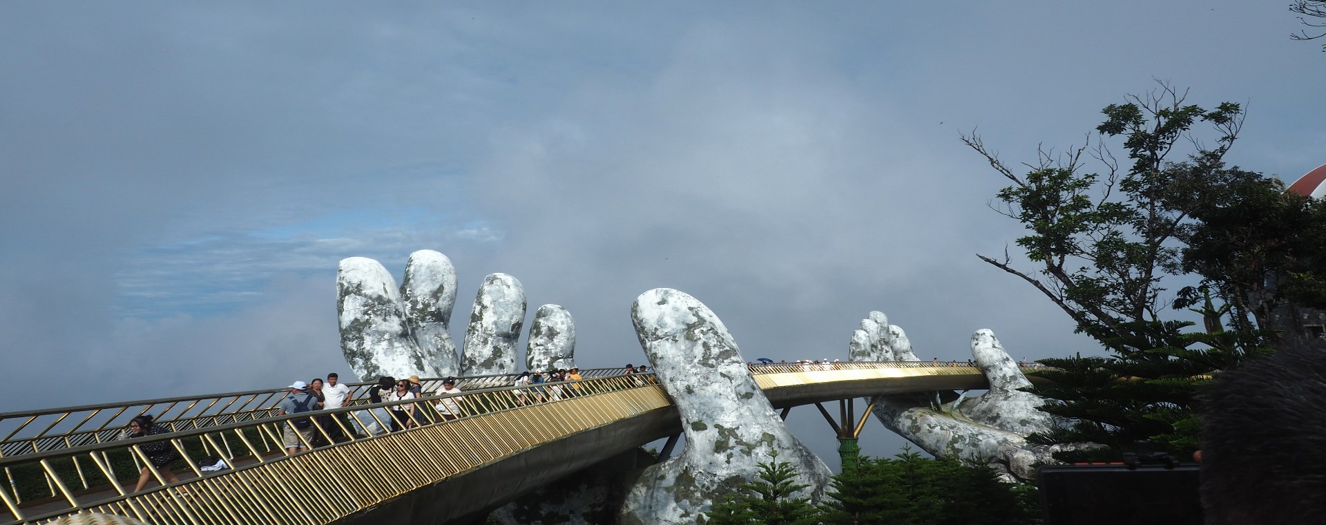 Pengunjung berjalan di atas Golden Bridge yang melengkung sepanjang 150 meter dengan lebar 12,8 meter, di perbukitan Ba Na, dekat kota Da Nang pada 28 Agustus 2022 - Bisnis/Farid Firdaus. 