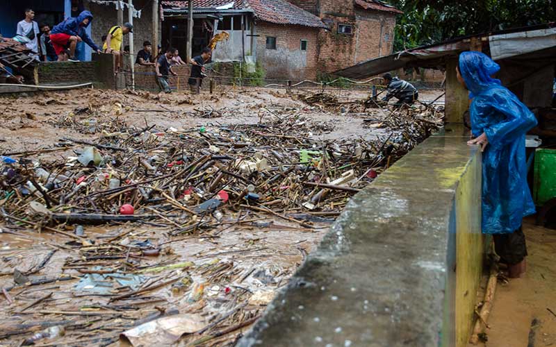 Warga membongkar jembatan penghubung yang dipenuhi sampah pada aliran sungai Cipagalo yang meluap di Kawasan Sukamiskin, Bandung, Jawa Barat, Jumat (26/11/2021). Warga kawasan tersebut membongkar jembatan penghubung akibat besarnya volume air dan sampah saat intensitas hujan tinggi agar tidak meluap ke permukiman. ANTARA FOTO/Novrian Arbi
