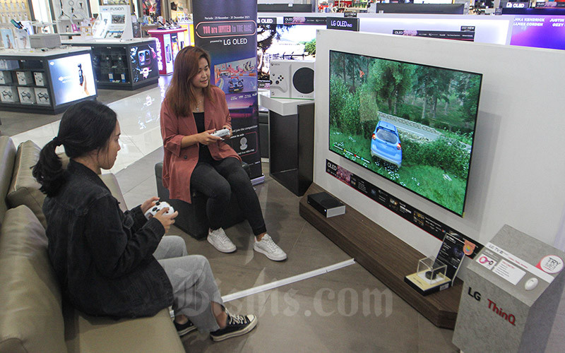 Calon pembeli mencoba permainan video yang ditampilkan layar TV OLED LG di Jakarta, Rabu (1/12/2021). PT LG Electronics Indonesia (LG) semakin gencar memperluas pemasaran TV OLED dengan menjangkau segmen untuk kebutuhan gaming, di antaranya dengan mengedepankan seri TV OLED C1. Pengembangan firmware pada TV OLED C1 dan G1 membuat LG tercatat sebagai pabrikan pertama yang memberi kemampuan dukungan Dolby VisionÂ® HDR pada resolusi 4K dan refresh rate 120Hz untuk gaming. Bisnis/Arief Hermawan P