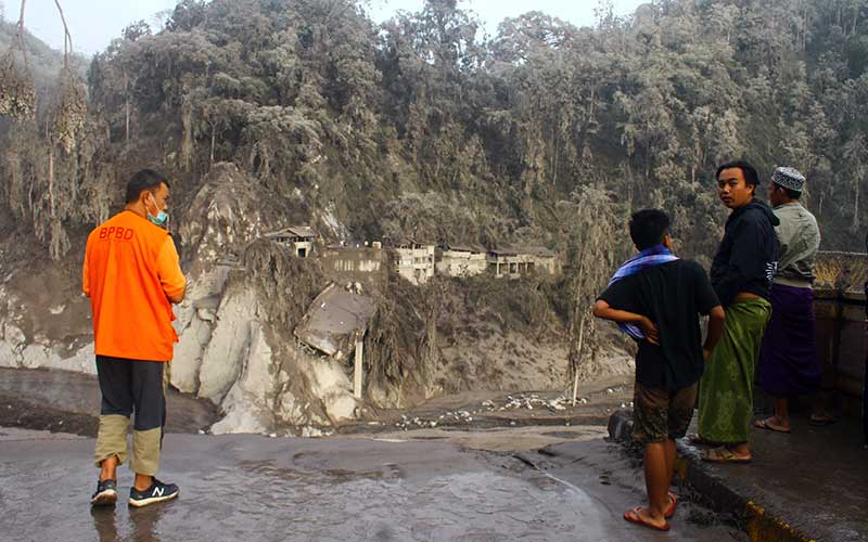 Sejumlah warga melihat jembatan Besuk Koboan atau biasa disebut Gladak Perak yang putus di Candipuro, Lumajang, Jawa Timur, Minggu (5/12/2021). Jembatan penghubung jalur Lumajang-Malang tersebut putus akibat diterjang lahar dingin usai gunung Semeru meletus.  ANTARA FOTO/Ari Bowo Sucipto