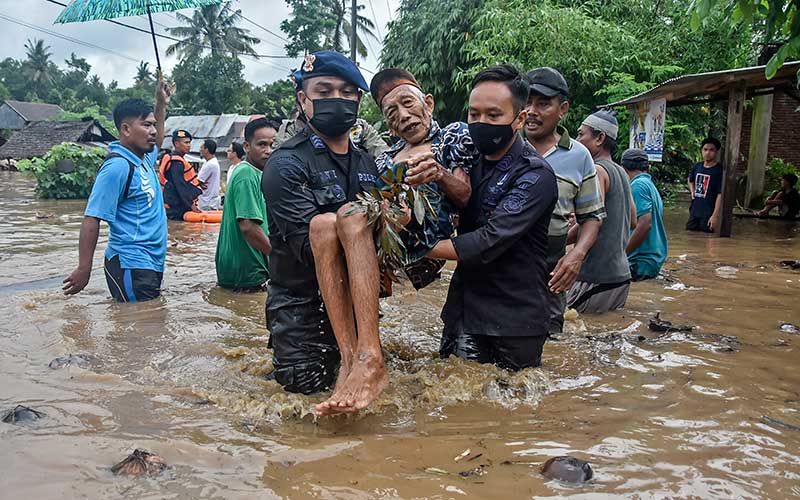 Sejumlah anggota Brimob Polda NTB mengevakuasi warga dari lokasi banjir di Dusun Kebon Lauk, Desa Sesela, Kecamatan Gunungsari, Lombok Barat, NTB, Senin (6/12/2021). Banjir yang terjadi karena hujan lebat dan luapan air Sungai Meninting di wilayah Gunungsari tersebut mengakibatkan ratusan rumah warga terendam. ANTARA FOTO/Ahmad Subaidi