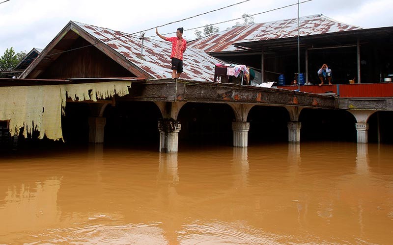 Warga berada di atap rumahnya saat terjadi banjir di Desa Pengaron, Kabupaten Banjar, Kalimantan Selatan, Rabu (12/1/2022). Sebanyak 2.215 kepala keluarga (KK) terdampak pada banjir yang melanda delapan desa di Kecamatan Pengaron dan merendam 2008 rumah itu. ANTARA FOTO/Bayu Pratama S