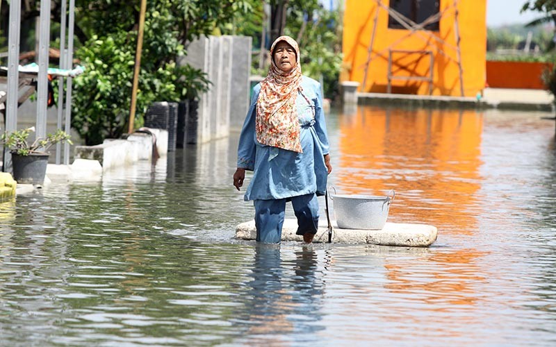 Warga korban banjir membawa air bersih di Desa Kedungringin Tengah, Beji, Pasuruan, Jawa Timur, Rabu (12/1/2022). Bantuan dari pemerintah daerah setempat itu ditujukan kepada warga yang kesulitan air bersih akibat banjir. ANTARA FOTO/Umarul Faruq