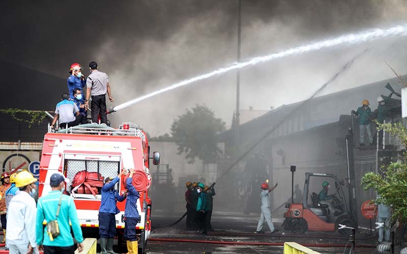 Petugas pemadam kebakaran berusaha memadamkan api yang membakar pabrik sepatu dan sandal di kawasan Buduran, Sidoarjo, Jawa Timur, Kamis (13/1/2022). Sebanyak sembilan unit mobil Pemadam Kebakaran (PMK) dikerahkan ke lokasi tersebut dan belum diketahui penyebabnya. ANTARA FOTO/Umarul Faruq
