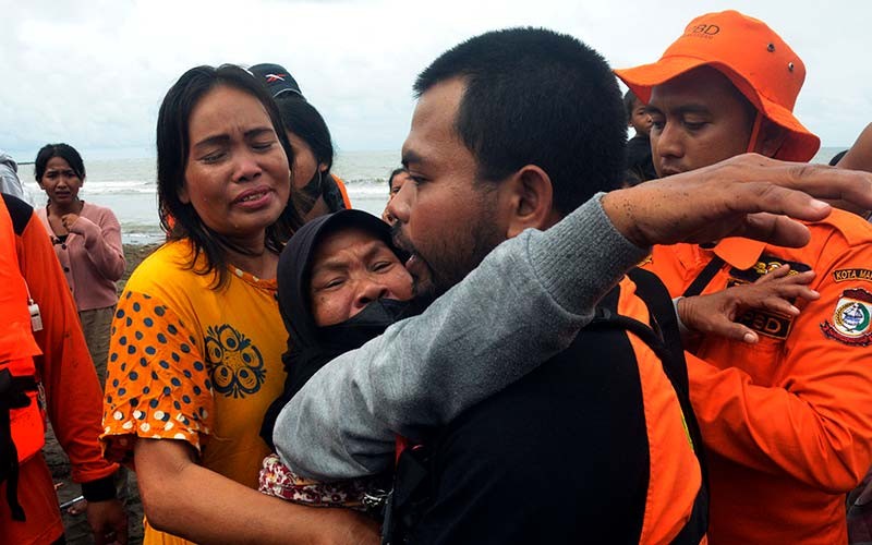 Keluarga korban menangis saat menyaksikan tim SAR gabungan mengevakuasi  korban tenggelam di Pantai Wisata Anging Mammiri, Makassar, Sulawesi Selatan, Senin (17/1/2022). Dua anak remaja yang tengelam saat bermain di Pantai pada (16/1/2022) tersebut ditemukan dalam keadaan meninggal dunia dan salah satunya ditemukan nelayan. ANTARA FOTO/Abriawan Abhe