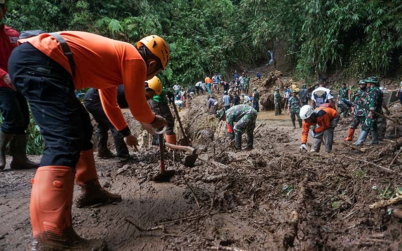 Sejumlah anggota TNI Kodim 0710 Pekalongan bersama petugas Badan Penanggulangan Bencana Daerah (BPBD) dan relawan membersihkan material longsor tanah yang menutupi jalan di Dukuh Tinalum, Kayupuring, Kecamatan Petungkriyono, Kabupaten Pekalongan, Jawa Tengah, Rabu (19/1/2022). Berdasarkan data Badan Penanggulangan Bencana Daerah (BPBD) setempat, sebanyak tiga titik di Dukuh Tinalum mengalami longsor tanah akibat hujan deras pada Selasa (18/1/2022) yang berimbas jalan alternatif menuju Banjarnegara terputus. ANTARA FOTO/Harviyan Perdana Putra