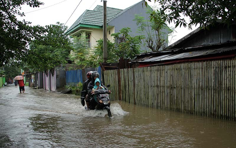 Pengendara sepeda motor menerobos banjir di Jalan Pasaran Keke, Kelurahan Batua, Makassar, Sulawesi Selatan, Kamis (20/1/2022). Banjir yang memutus akses kendaraan menuju salah satu permukiman penduduk itu akibat hujan dengan intensitas tinggi yang mengguyur daerah itu sejak Selasa (18/1/2022). ANTARA FOTO/Arnas Padda