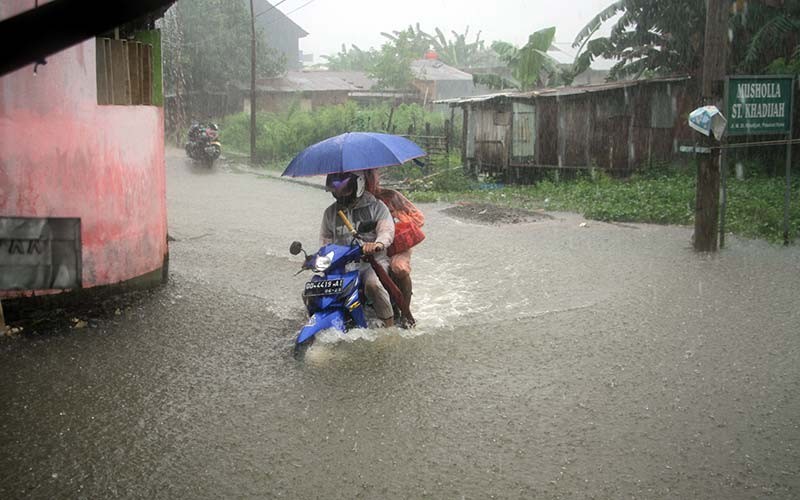 Pengendara sepeda motor menerobos banjir di Jalan Pasaran Keke, Kelurahan Batua, Makassar, Sulawesi Selatan, Kamis (20/1/2022). Banjir yang memutus akses kendaraan menuju salah satu permukiman penduduk itu akibat hujan dengan intensitas tinggi yang mengguyur daerah itu sejak Selasa (18/1/2022). ANTARA FOTO/Arnas Padda