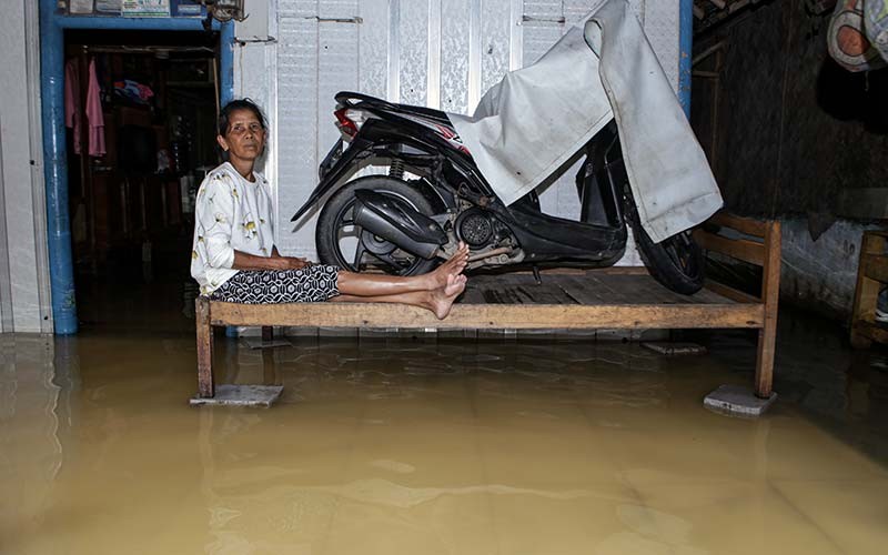 Seorang warga duduk di halaman rumahnya yang terendam banjir di Pakuhaji, Kabupaten Tangerang, Banten, Kamis (20/1/2022). Intensitas hujan yang tinggi sejak Selasa (18/1) menyebabkan empat kampung di kecamatan tersebut terendam banjir dan mengakibatkan 660 KK terdampak. ANTARA FOTO/Fauzan