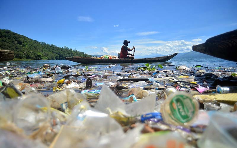 Nelayan mengayuh biduk di antara sampah di tepian Danau Singkarak, Nagari Sumpu, Kabupaten Tanah Datar, Sumatera Barat, Kamis (20/1/2022). Tepian danau wisata tersebut dipenuhi sampah plastik sejak sepekan terakhir yang menyulitkan nelayan mencari ikan. ANTARA FOTO/Iggoy el Fitra