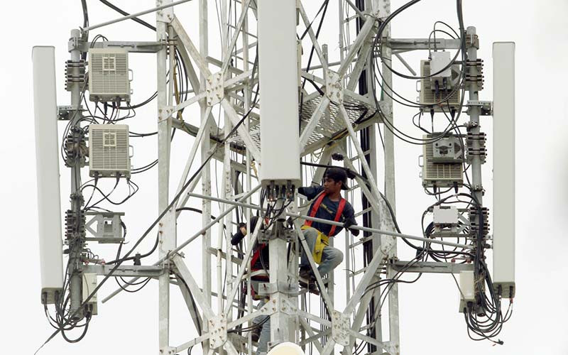 Pekerja melakukan perbaikan perangkat telekomunikasi di tower base transceiver station (BTS) di Makassar, Sulawesi Selatan, Selasa (25/1/2022). Kementerian Komunikasi dan Informatika (Kemenkominfo) mematangkan rencana lelang pita frekuensi 700 MHz untuk layanan internet bergerak. Apabila tidak ada halangan, lelang akan dilakukan pada tahun ini. Bisnis/Paulus Tandi Bone
