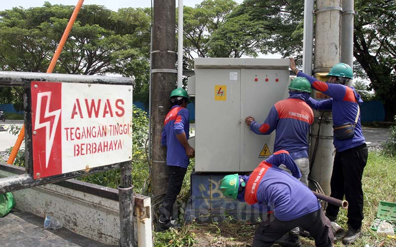 Teknisi rekanan PT PLN mengerjakan penggantian perangkat listrik yang lama dengan yang baru guna menjaga distribusi listrik ke pelanggan tetap terjaga di Makassar, Sulawesi Selatan, Selasa (25/1/2022). Hingga Desember 2021 PT PLN Unit Induk Wilayah Sulawesi Selatan Tenggara dan Barat (Sulselrabar) mencatatkan panjang jaringan tegangan menengah 26.486,37 kilometer sirkuit (KMS), jaringan rendah 27.079,14 kms, dengan total kapasitas gardu distribusi 3.218 kilo volt amper (KVA). Bisnis/Paulus Tandi Bone