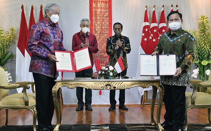 Presiden Joko Widodo (kedua kanan) dan Perdana Menteri Singapura Lee Hsien Loong (kedua kiri) menyaksikan Menteri Pertahanan Prabowo Subianto (kanan) dan Menteri Pertahanan Singapura Ng Eng Hen memperlihatkan dokumen kesepakatan memberlakukan perjanjian pertahanan 2007 di The Sanchaya Resort Bintan, Kabupaten Bintan, Kepulauan Riau, Selasa (25/1/2022). ANTARA FOTO/HO/Setpres/Agus Suparto
