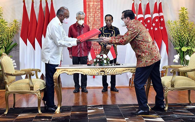 Presiden Joko Widodo (kedua kanan) dan Perdana Menteri Singapura Lee Hsien Loong (kedua kiri) menyaksikan Menkum Ham Yasonna Laoly (kanan) dan Mendagri Singapura K Shanmugam bertukar dokumen terkait perjanjian ekstradisi di The Sanchaya Resort Bintan, Kabupaten Bintan, Kepulauan Riau, Selasa (25/1/2022). ANTARA FOTO/HO/Setpres/Agus Suparto