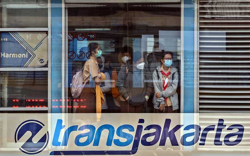 Penumpang menunggu kedatangan bus Transjakarta di halte Harmoni, Jakarta, Rabu (26/1/2022). PT Transportasi Jakarta (Transjakarta) melakukan penyesuaian jam layanan operasional dimulai pukul 05.00-21.30 WIB dan untuk layanan malam hari pukul 21.31-22.30 WIB pada masa Pemberlakuan Pembatasan Kegiatan Masyarakat (PPKM) Level 2 di Jakarta dengan kapasitas normal 100 persen. Bisnis/Eusebio Chrysnamurti