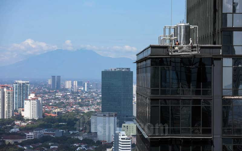 Pekerja menggunakan gondola beraktivitas di salah satu gedung bertingkat di Jakarta, Jumat (13/5/2022). Pemerintah menyatakan akan mengubah postur Anggaran Pendapatan dan Belanja Negara (APBN) 2022 seiring dinamika kondisi saat ini, terutama karena kasus Covid-19 yang relatif melandai. Meredanya penularan kasus tersebut membuat anggaran penanganan pandemi perlahan dapat beralih ke fungsi lain. Bisnis/Himawan L Nugraha