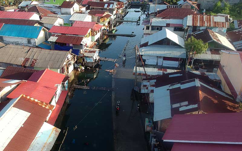 Warga melewati banjir rob yang menggenangi kawasan perkampungan nelayan di Purus Atas, Kota Padang, Sumatera Barat, Rabu (18/5/2022). Banjir rob menggenangi permukiman penduduk di sejumlah titik di kota Padang sejak tiga hari terakhir. ANTARA FOTO/Iggoy el Fitra