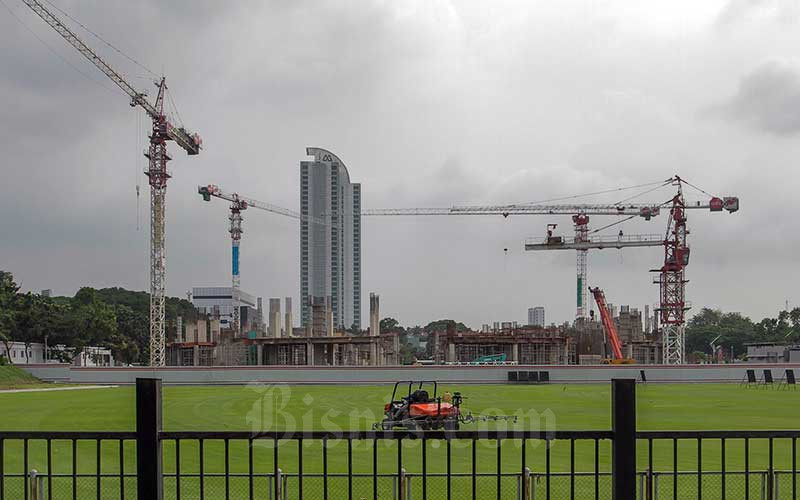 Pekerja beraktivitas di dekat proyek pembangunan venue di Jakarta, Sabtu (21/5/2022). Badan Pusat Statistik (BPS) mencatat pada Triwulan I tahun 2022 sektor real estate dan konstruksi tumbuh masing-masing sebesar 3,78 persen dan 4,83 persen secara tahunan. Bisnis/Fanny Kusumawardhani