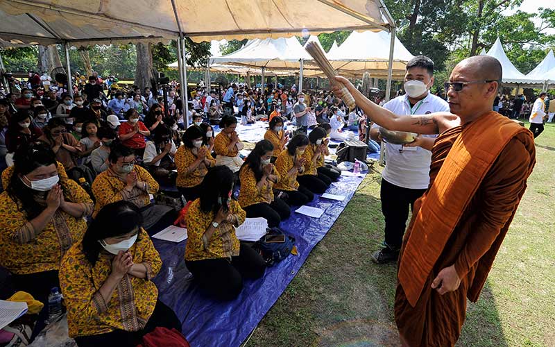 Seorang Banthe memercikkan air suci kepada umat saat perayaan bersama Waisak 2566 BE/2022 di Candi Kedaton, Kawasan Cagar Budaya Nasional (KCBN), Muarojambi, Jambi, Minggu (22/5/2022). Perayaan bersama yang dikuti ribuan umat Buddha setempat itu mengangkat tema âModerasi Beragama Membangun Kedamaianâ. ANTARA FOTO/Wahdi Septiawan
