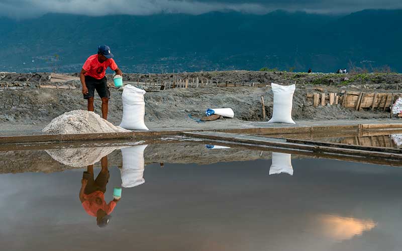 Petani memasukkan garam yang baru dipanen ke dalam karung di Palu, Sulawesi Tengah, Rabu (25/5/2022). Sejumlah petani garam di wilayah itu mengaku mengalami penurunan produksi garam selama tahun ini sekitar 20 persen dibanding sebelumnya karena faktor anomali cuaca. ANTARA FOTO/Basri Marzuki