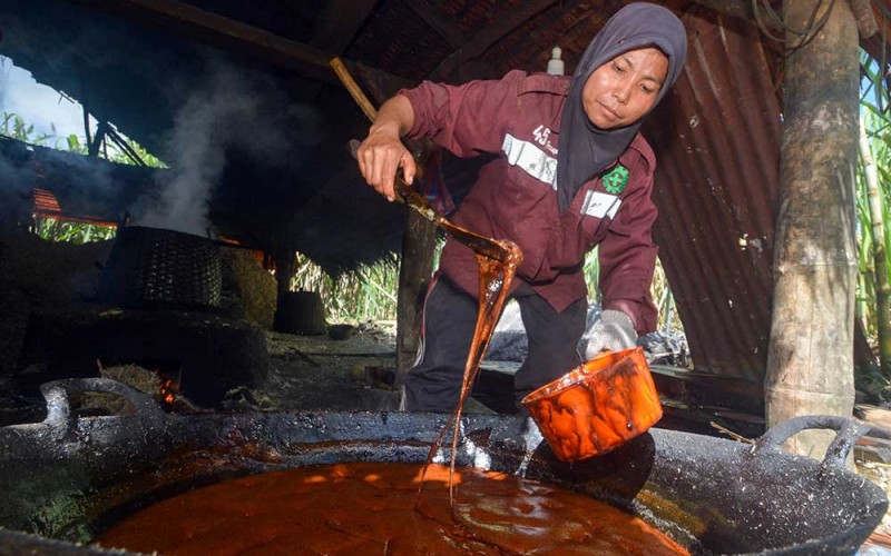 Perajin menyendok gula merah atau "Saka" di Nagari Lawang, Kabupaten Agam, Sumatera Barat, Rabu (22/6/2022). Menurut perajin, gula merah terbuat dari tebu yang diolah secara tradisional tersebut kini harga jualnya membaik mulai Rp12 ribu hingga Rp14 ribu per kilogram. ANTARA FOTO/Iggoy el Fitra