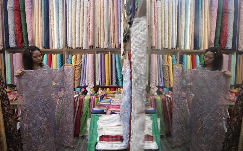 Pegawai merapikan kain di salah satu gerai penjualan di Tanah Abang, Jakarta, Jumat (1/7/2022). Asosiasi Serat dan Benang Filament Indonesia (APSyFI) menyampaikan saat ini porsi ekspor komoditas tekstil dan produk tekstil (TPT) antara lain, Amerika Serikat dengan porsi sebesar 30%, Jepang 10% dan Uni Eropa 30%. Bisnis/Himawan L Nugraha