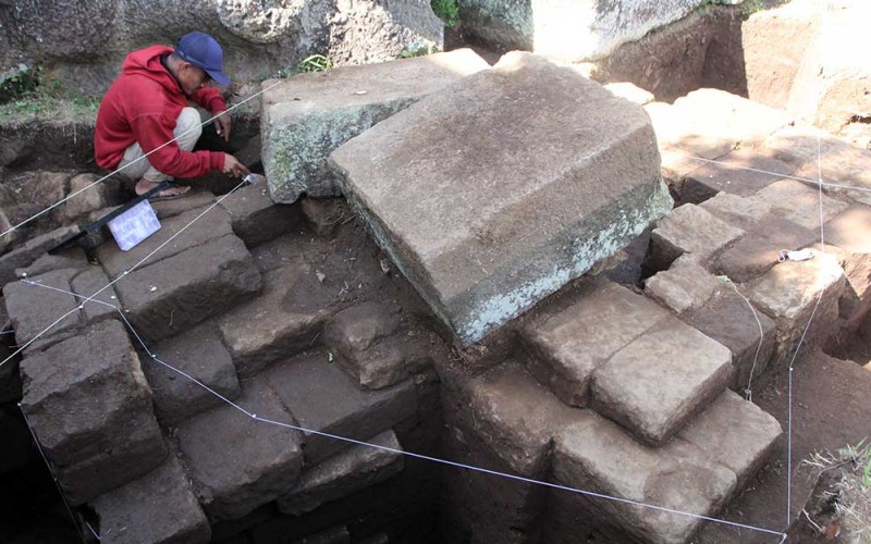 Arkeolog dari Balai Pelestarian Cagar Budaya (BPCB) Jawa Timur membersihkan struktur batu kuno yang ditemukan saat dalam ekskavasi di situs Arca Dwarapala, Singosari, Malang, Jatim, Senin (4/7/2022).  Dalam ekskavasi tersebut arkeolog juga menemukan struktur batu dari abad 12 Masehi. ANTARA FOTO/Ari Bowo Sucipto
