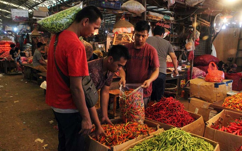 Pedagang cabai melayani pembeli di Pasar Induk Kramat Jati, Jakarta, Senin (4/7/2022). Sejumlah pedagang mengeluhkan sepinya pembeli akibat kenaikan bahan pangan dalam sepekan terakhir seperti cabai merah keriting dari Rp75.000 menjadi Rp85.000 per kilogram, cabai rawit merah dari Rp80.000 menjadi Rp95.000 per kilogram, bawang merah dari Rp35.000 menjadi Rp55.000 per kilogram, bawang putih dari Rp12.000 menjadi Rp20.000 per kilogram yang dipicu minimnya pasokan dari distributor dan menjelang hari raya Idul Adha. ANTARA FOTO/Budi Prasetiyo