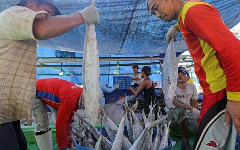 Pekerja membongkar ikan untuk dijual di pelabuhan ikan Karangsong, Indramayu, Jawa Barat, Selasa (5/7/2022). Kementerian Kelautan dan Perikanan (KKP) menargetkan angka konsumsi ikan sebesar 62,05 kilogram per kapita per tahun pada tahun 2024 melalui diversifikasi olahan perikanan. ANTARA FOTO/Dedhez Anggara