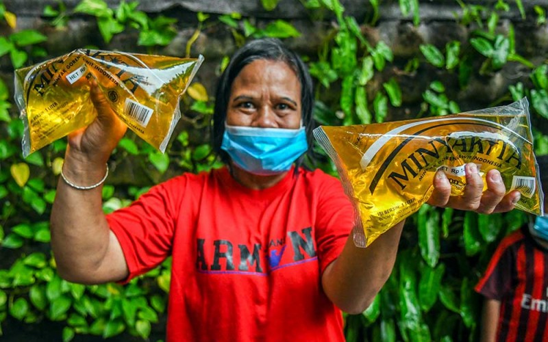 Warga memperlihatkan minyak goreng kemasan saat peluncuran minyak goreng kemasan rakyat (MinyaKita) di kantor Kementerian Perdagangan, Jakarta, Rabu (6/7/2022). Kementerian Perdagangan meluncurkan minyak goreng curah kemasan sederhana dengan harga Rp14.000 per liter.  ANTARA FOTO/Galih Pradipta