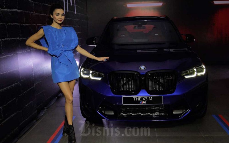 Model berpose di dekat mobil New BMW X3 M Competition dan BMW X4 M Competition di Jakarta, Kamis (7/7/2022). Bisnis/Fanny Kusumawardhani rn