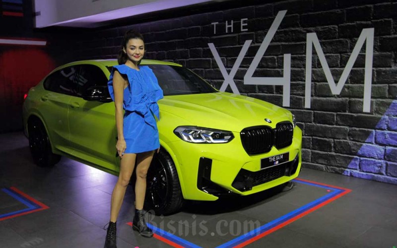 Model berpose di dekat mobil New BMW X3 M Competition dan BMW X4 M Competition di Jakarta, Kamis (7/7/2022). Bisnis/Fanny Kusumawardhani 