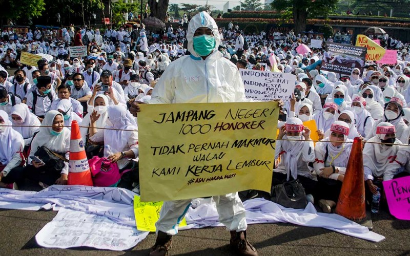 Peserta aksi yang tergabung dalam Forum Komunikasi Honorer Fasilitas Pelayanan Kesehatan (fasyankes) Jawa Barat berunjuk rasa di depan Gedung Sate, Bandung, Jawa Barat, Jumat (5/8/2022). Dalam aksinya, tenaga kesehatan honorer tersebut menuntut untuk non-ASN nakes dan non-nakes yang bekerja di fasyankes pemerintah baik di puskesmas maupun rumah sakit untuk segera diakomodir dan diangkat sebagai ASN maupun PPPK menyesuaikan PP nomor 49 tahun 2018. ANTARA FOTO/Novrian Arbi