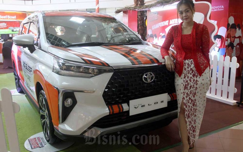Model berfoto dengan mobil Toyota yang dipamerkan di Makassar, Sulawesi Selatan, Rabu (10/8/2022). Bisnis/Paulus Tandi Bone