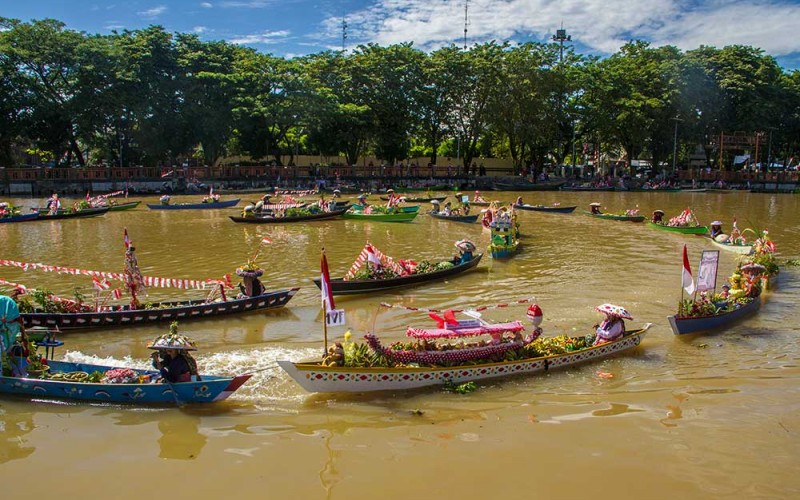 Pedagang pasar terapung melakukan atraksi meggunakan perahu (jukung) membuat bunga mekar saat Festival Budaya Pasar Terapung di Sungai Martapura, Banjarmasin, Kalimantan Selatan, Senin (15/8/2022). Atraksi yang dilakukan puluhan pedagang pasar terapung  itu digelar unutk memeriahkan HUT ke-77 RI dan puncak HUT Provinsi Kalimantan Selatan ke-72. ANTARA FOTO/Bayu Pratama S