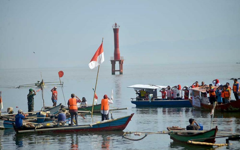 Sejumlah nelayan dan warga mengikuti upacara pengibaran Bendera Merah Putih di Muaro Sungai Batang Arau, Padang, Sumatera Barat, Rabu (17/8/2022). Upacara bendera tersebut digelar Pokdarwis Gunung Padang bersama nelayan dan Koalisi Masyarakat Peduli Batang Arau dalam rangka memperingati HUT Kemerdekaan RI ke-77 sekaligus mengkampanyekan kebersihan muara dan sungai. ANTARA FOTO/Iggoy el Fitra