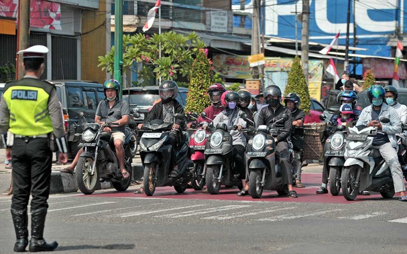 Petugas kepolisian memandu pengendara untuk menghentikan kendaraannya saat peringatan detik-detik Proklamasi Kemerdekaan RI di Simpang Jelutung, Jambi, Rabu (17/8/2022). Lalu lintas kendaraan di semua persimpangan jalan di kota itu dihentikan serentak selama tiga menit untuk memperingati detik-detik Proklamasi Kemerdekaan RI. ANTARA FOTO/Wahdi Septiawan
