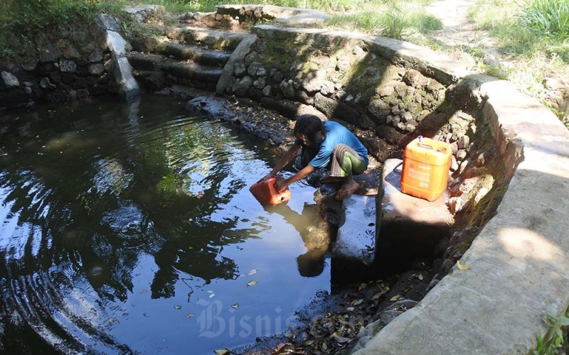 Seorang warga mengambil air di sumur yang mulai berkurang debit airnya di Desa Jatisari, Arjasa, Situbondo, Jawa Timur, Jumat (19/8/2022). Warga Desa Jatisari setiap tahunnya selalu menemui kesulitan mengakses air bersih untuk kebutuhan minum dan terpaksa mengambil air dengan jarak terdekat sekitar dua kilometer perjalanan. ANTARA FOTO/Seno