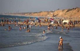 GENJATAN SENJATA DISIKAPI BERBEDA: Warga Israel Berjemur di Pantai, Orang Palestina Mencari Sisa Reruntuhan Rumah