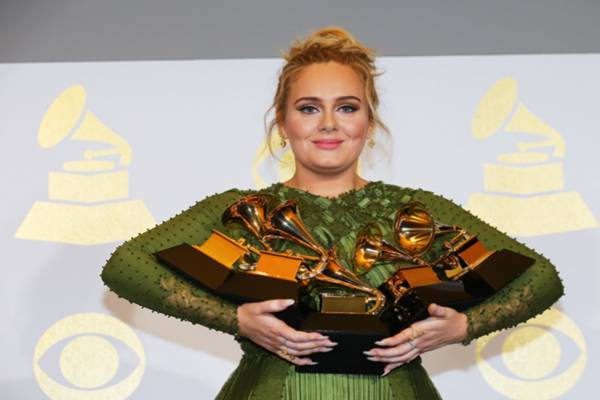 Adele memengang lima piala Grammy. - .Reuters
