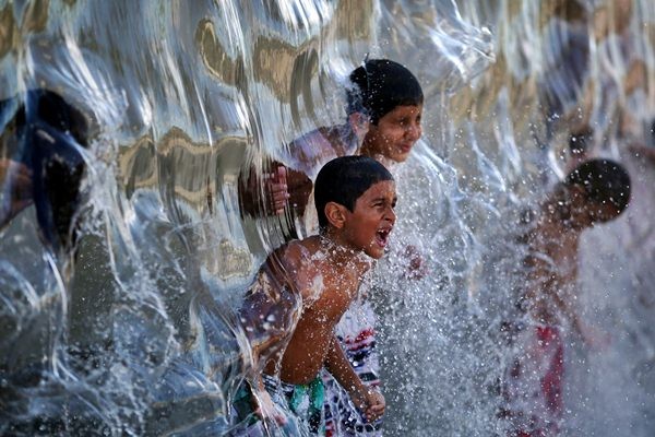 Anak-anak bermain air. - Reuters/Pilar Olivares