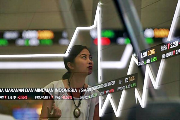 Karyawati beraktivitas di dekat papan elektronik yang menampilkan pergerakan Indeks Harga Saham Gabungan (IHSG) di Bursa Efek Indonesia. - JIBI/Abdullah Azzam