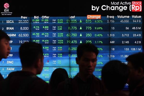 Pengunjung beraktivitas di dekat layar papan elektronik yang menampilkan indeks harga saham gabungan (IHSG) di kantor PT Bursa Efek Indonesia di Jakarta, Senin (23/10). - JIBI/Dedi Gunawan