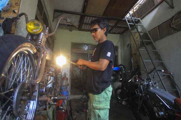 Pegawai bengkel motor custom menyelesaikan perakitan sepeda motor modifikasi yang dipesan pembeli di Bengkel Bre, Solo, Jawa Tengah, Rabu (31/1).  - Antara