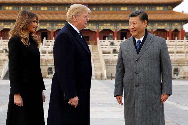 Presiden China Xi Jinping (kanan) berinteraksi dengan Presiden AS Donald Trump didampingi Melania Trump. (Reuters)