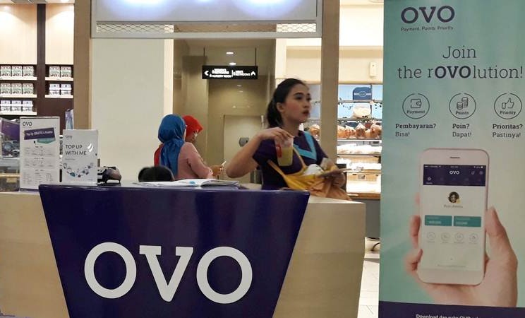 Karyawan melintas di gerai transaksi pembayaran digital OVO, di Jakarta, Senin (25/3/2019). - Bisnis/Endang Muchtar