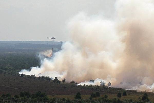Helikopter BNPB jenis MI-8 melakukan pengeboman air di atas areal hutan dan lahan yang terbakar di Desa Medang Kampai, Dumai, Riau, Selasa (9/8). - Antara
