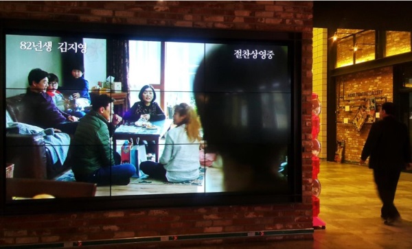 Seorang penonton berjalan di dekat layar yang memainkan trailer "Kim Ji - young, Born 1982&quot; di sebuah bioskop di Seoul, Korea Selatan 30 Oktober 2019.