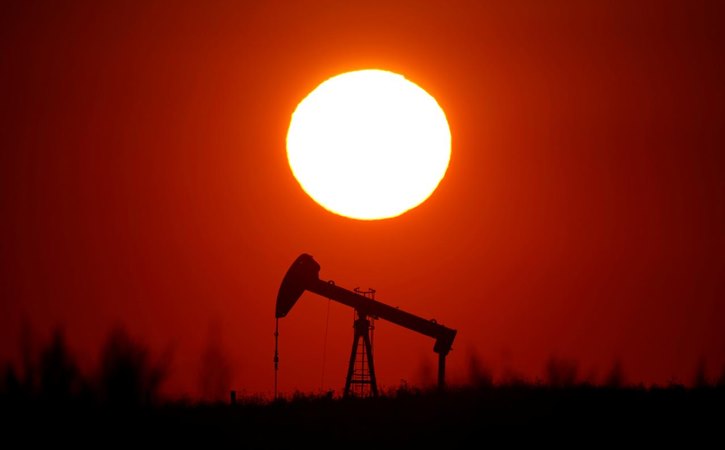 Matahari terbenam di belakang sebuah pompa minyak di luar Saint-Fiacre, dekat Paris, Prancis 17 September 2019. - REUTERS/Christian Hartmann